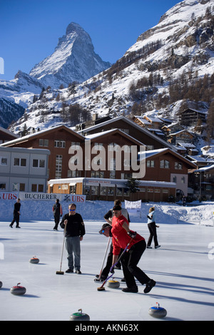 Les gens sur une patinoire de curling en arrière-plan le Mont Cervin Zermatt Valais Suisse Banque D'Images