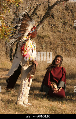 Un Native American Indian raconter des histoires au cours de l'automne avec sa fille à genoux et l'écoute Banque D'Images