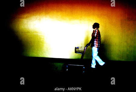 Un homme poussant un chariot dans un aéroport Banque D'Images