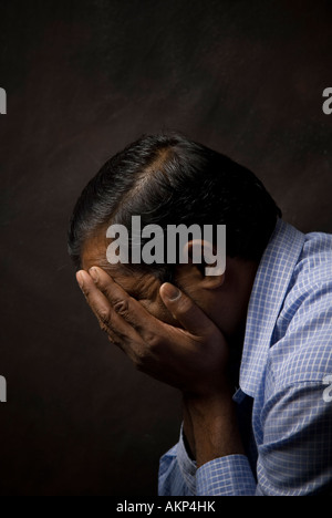 L'homme indien head in hands Banque D'Images