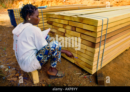 Une femme cadre chambres prêtes pour l'expédition dans une scierie en Côte d'Ivoire Banque D'Images