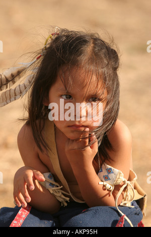 Les jeunes Native American boy sitting on a log à la recherche désespérée ou versement Banque D'Images