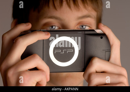 Un jeune adolescent jouant sur Sony PSP ordinateur de poche à une console de jeux. Banque D'Images