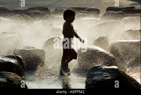 Un enfant joue dans une fontaine à l'extérieur du Centre scientifique de l'Université Harvard, Cambridge, Massachusetts Banque D'Images