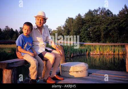 Pologne, petit-fils et son grand-père sur l'étang de l'eau jetée Banque D'Images