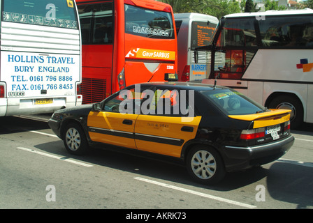 Barcelone vue rapprochée emblématique taxi noir et jaune avec passager dans un embouteillage derrière un car anglais animé rue espagnole Catalogne Espagne UE Banque D'Images