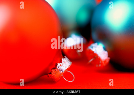 Close up de trois rouge et vert lumineux boules de Noël sur fond rouge Banque D'Images