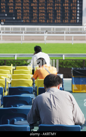 Les hommes qui étudient à l'hippodrome de Shatin Guides Formulaire de Hong Kong Banque D'Images
