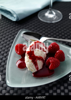 Une quenelle de mousse au chocolat blanc avec coulis de framboise editorial food Banque D'Images