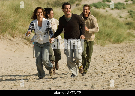Deux couples d'exécution sur la plage Banque D'Images