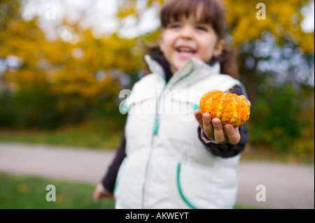 Girl (4-5) holding pupmkin, close-up Banque D'Images