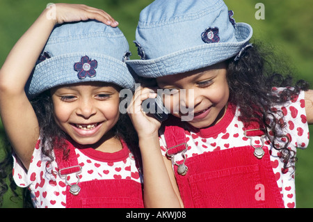 Twin Sisters talking on mobile phone Banque D'Images