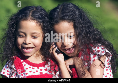 Twin Sisters talking on mobile phone Banque D'Images