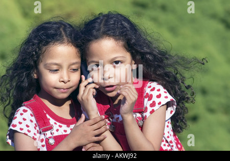 Twin Sisters talking on mobile phone Banque D'Images