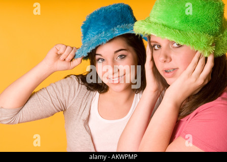 Portrait de deux adolescentes (15-17) portant des chapeaux colorés, Smiling USA Banque D'Images