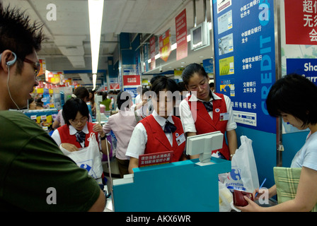 Ligne les consommateurs à payer à un comptoir du caissier dans un supermarché Carrefour à Beijing Chine 22 juil 2006 Banque D'Images