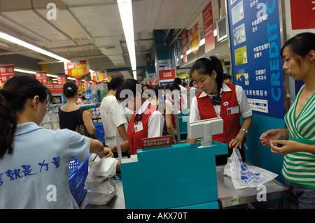 Ligne les consommateurs à payer à un comptoir du caissier dans un supermarché Carrefour à Beijing Chine 22 juil 2006 Banque D'Images