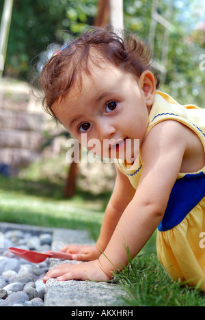 Fille, 10 mois, jouant dans le jardin Banque D'Images