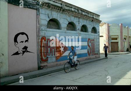 Cycliste dans les rues de La Havane, drapeau cubain peint sur un mur, Cuba Banque D'Images