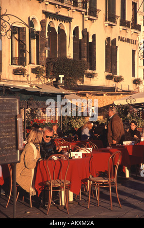Venise, Italie. Les personnes bénéficiant d'une soirée d'hiver soleil et manger en plein air sur la Riva degli Schiavoni Banque D'Images