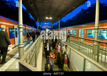 Les passagers de descendre de train à une plate-forme au crépuscule, Hesse, Allemagne Banque D'Images