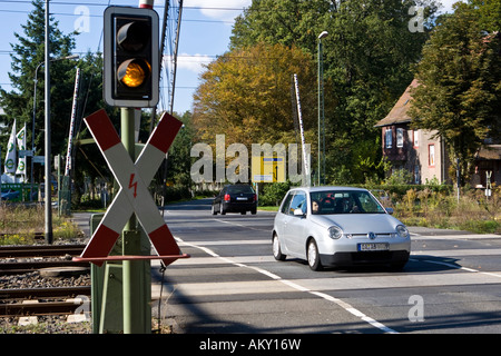 Voiture roule sur un passage à niveau avec des portes ouvertes, avec St Andrew's Cross et jaune feu, Hessen, Germa Banque D'Images