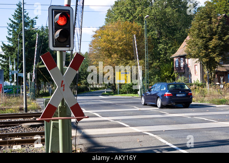 Voiture roule sur un passage à niveau avec des portes ouvertes, avec St Andrew's Cross et le feu rouge, Hessen, Allemagne Banque D'Images