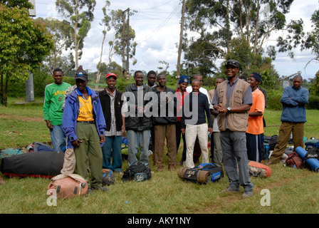 Guide de montagne local avec les porteurs assemblés à Marangu Gate Kilimandjaro Tanzanie Banque D'Images