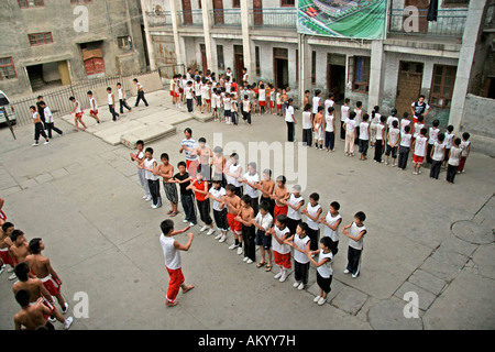 Les enfants dans le Gong Fu Wuzhi dans la cour de l'école sont alignées en deux rangées, KungFu, Taiji, Wuzhi, Henan, Chine Banque D'Images