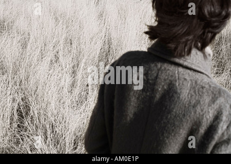 Vue arrière de la femme marche à travers champ d'automne Banque D'Images