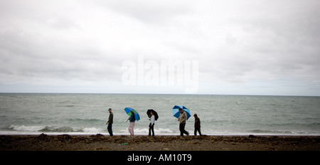 Balades en famille sur la plage sous la pluie august bank holiday weekend d'Aberystwyth, Ceredigion Pays de Galles UK Banque D'Images