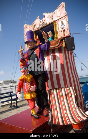 Une femme Punch et Judy Le professeur avec ses marionnettes faites à la main et rouge et blanc à rayures booth, Aberystwyth Wales UK Banque D'Images