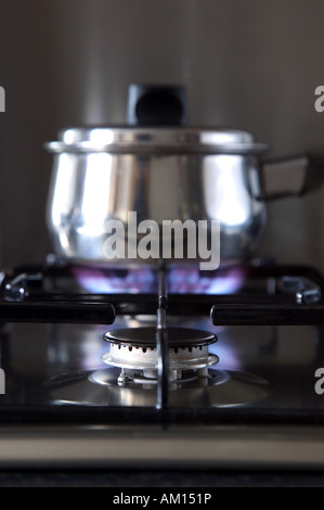 Gros plan d'une cuisinière à gaz avec une casserole sur le brûleur arrière DOF peu profondes Banque D'Images