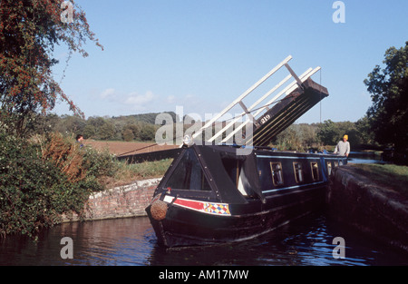 La direction de l'homme 15-04 par espace étroit sous le pont cantilever sur Oxford Canal, près de Thrupp, Oxfordshire, Angleterre Banque D'Images