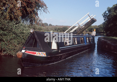 La direction de l'homme 15-04 par espace étroit sous le pont cantilever sur Oxford Canal, près de Thrupp, Oxfordshire, Angleterre Banque D'Images