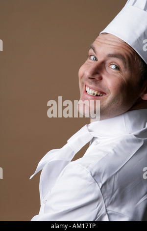 Smiling cook, regarder par-dessus l'épaule Banque D'Images
