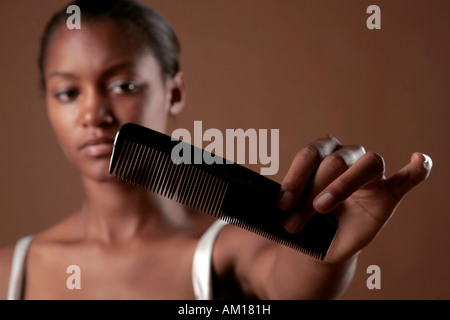 Jeune femme à la peau sombre avec comb Banque D'Images