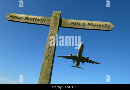 Un avion de ligne arrive en terre à l'aéroport de Londres Gatwick, sur un signe de diriger pour randonneurs sur les sentiers des terres agricoles adjacentes Banque D'Images