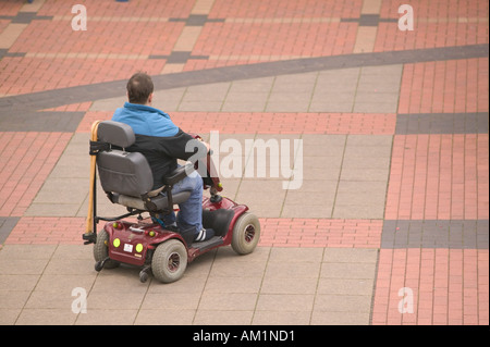 Un homme handicapé sur un scooter de mobilité dans le centre commercial de Burnley Lancashire Banque D'Images