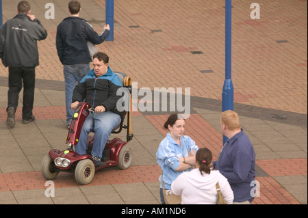 Homme handicapé dans un scooter de mobilité dans le centre commercial de Burnley Lancashire Banque D'Images