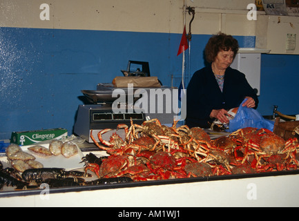 Dame poissonnier vend des crabes et homards dans le marché aux poissons, St Peter Port, Guernsey, Channel Islands Banque D'Images