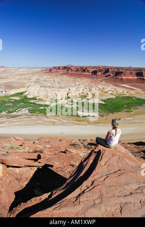 Femme à la recherche au cours de la Glen Canyon National Recreation Area de la Hite vue, Plateau du Colorado, Utah, USA Banque D'Images