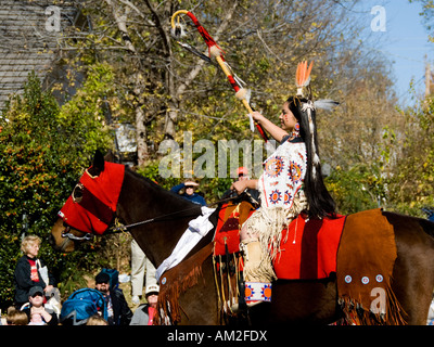 Une belle, American Indian girl en costume national rides son cheval dans la rue dans un défilé. Banque D'Images