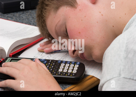 Bored student sleeping tout en faisant leurs devoirs de mathématiques Banque D'Images