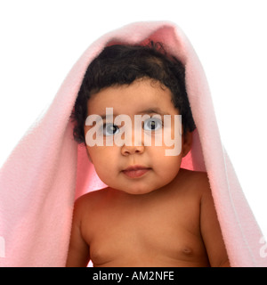 Un très mignon bébé regarde de sous une couverture bébé Banque D'Images