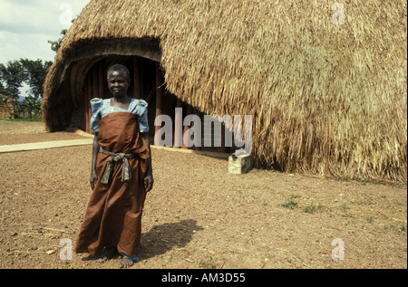 Tombeau Kabakas Kasubi Royal de Chambre circulaire Batterie Kampala, capitale de l'Ouganda Afrique de l'Est avec la dame guide le port de tissu d'écorce Banque D'Images