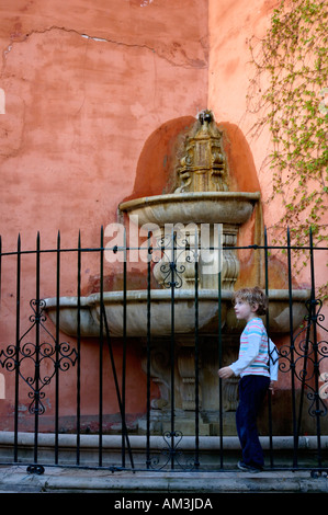 Jeu de fille à côté d'une fontaine d'eau sur la Juderia Street, dans le quartier de Barrio Santa Cruz à Séville, Andalousie, espagne. Banque D'Images