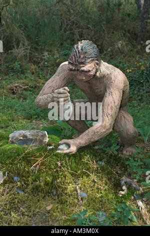 Modèle grandeur nature l'Homo erectus en utilisant des outils de pierre Dinosaur Park France Banque D'Images