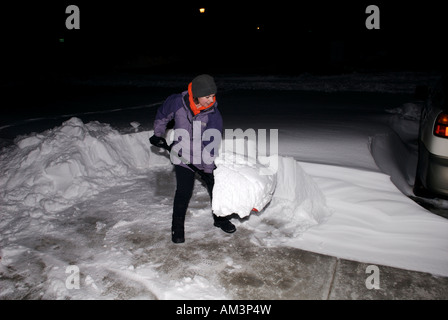 Jeune femme pelles une profonde dérive de neige de son allée pendant la tempête de décembre 2006 à Fort Collins, Colorado, USA Banque D'Images