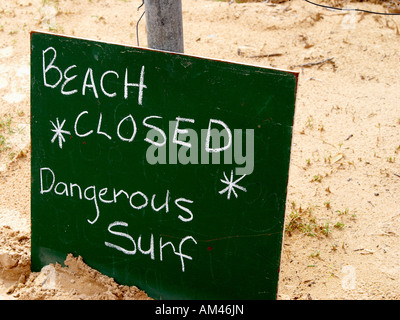 Un signe indiquant qu'une plage de surf est fermée en raison de conditions dangereuses. Banque D'Images